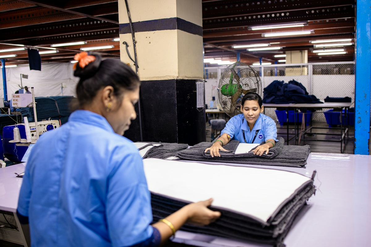 Factory workers folding fabric inside a garment factory